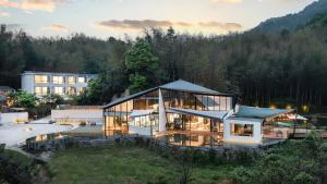 a large house with glass windows and a building at Congxi Creek Resort in Conghua