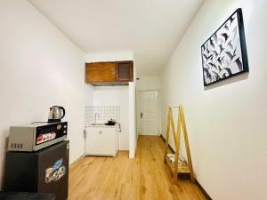 a kitchen with a refrigerator and a microwave on a wall at Home in Old Quarter HÀ NỘI - Ta Hien street in Hanoi +20 photos