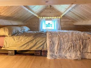 a bed in a room with a wooden ceiling at Tiny Häuschen Land-Idyll in Neuhof