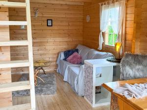 a living room with a couch in a log cabin at Tiny Häuschen Land-Idyll in Neuhof