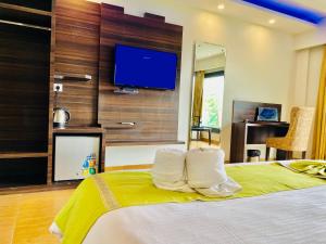 una camera da letto con un letto grande con una TV a parete di Royal Green Valley Mashobra by Naina Staycation - Mountain and valley view rooms a Shimla