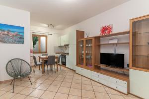 Guest House in the Center of Olbia في أولبيا: غرفة معيشة مع تلفزيون وغرفة طعام