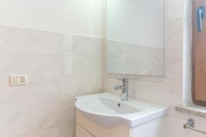Guest House in the Center of Olbia في أولبيا: حمام أبيض مع حوض ومرآة +13 صورة