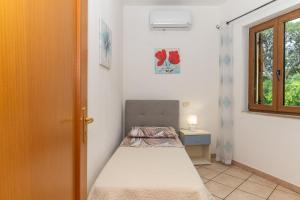 Guest House in the Center of Olbia في أولبيا: غرفة نوم صغيرة بها سرير ونافذة