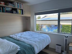 a bedroom with a bed and a large window at Kombi Cottage Fully accessible in Tairua +69 photos