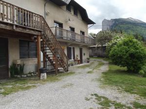 a house with a wooden staircase on the side of it at Le Playon, classification 3 étoiles in Lus-la-Croix-Haute