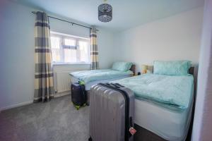 ein Schlafzimmer mit einem Einzelbett und einem Koffer in der Unterkunft Artisan Sanctuary in Lincoln