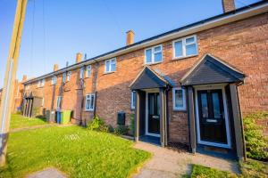 ein Backsteingebäude mit zwei Türen und einem Rasenplatz in der Unterkunft Artisan Sanctuary in Lincoln
