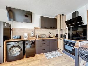 una cucina con lavatrice e lavatrice di Appartement rez de jardin proche du centre ville de sarzeau a Sarzeau