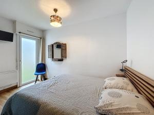 una camera da letto con un letto e una finestra di Appartement rez de jardin proche du centre ville de sarzeau a Sarzeau Altre 10 foto