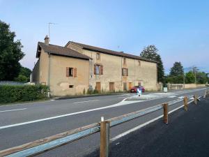 a building on the side of a road with a motorcycle at Le Clos des Cadots - Apt 2ème Sud in Chaintré