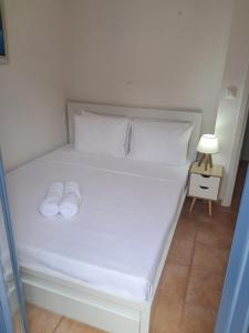a white bed with two white pillows and a lamp at Agia Effimia RIVIERA APPARTMENT in Agia Effimia