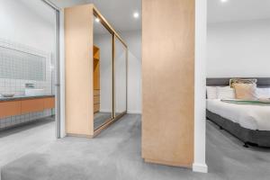 a bedroom with a mirror next to a bed at Allure - stunning in central Port Fairy in Port Fairy +12 photos