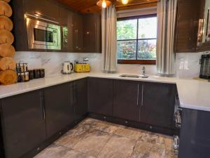 a kitchen with black cabinets and a sink and a window at Starwood in Morpeth +34 photos