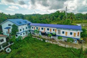 a large white building with a blue roof at The Soul Center in Batuan
