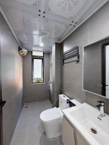 a bathroom with a white toilet and a sink at CAT BA Villas 5 Rooms in Cat Ba