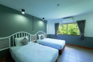 a bedroom with two beds and a window in it at Nora Bukit Hotel in Ban Sam Kong +128 photos