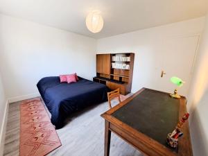 a bedroom with a bed and a table in it at Nonni, Maison Familiale - Royan in Royan