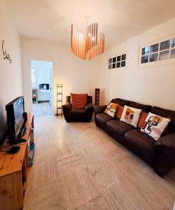 a living room with a couch and a television at Nonni, Maison Familiale - Royan in Royan