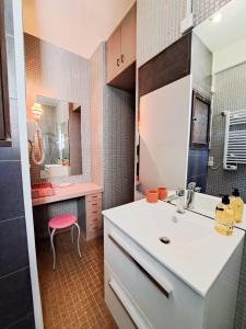 a small kitchen with a sink and a red stool at Nonni, Maison Familiale - Royan in Royan +33 photos