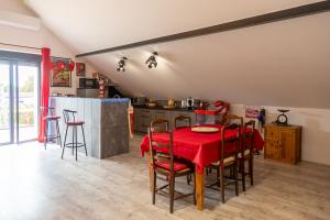 a kitchen with a red table and chairs in a room at L'écurie in Floirac