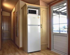 a white refrigerator with a microwave on top of it at Camping Bungalows Sol D´Or in Peniscola +38 photos