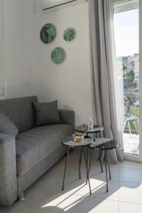 a living room with a couch and two tables at Chrysi Guesthouse in Rethymno