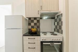 a kitchen with a white stove and a refrigerator at Chrysi Guesthouse in Rethymno