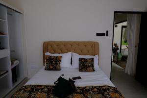 Una cama con una bolsa negra encima. en villa barakah, en Bentong