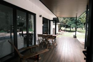un porche con mesa de madera y sillas en villa barakah, en Bentong