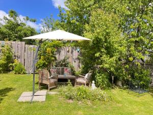 a table and two chairs under an umbrella in a yard at Roulotte à Honfleur in Honfleur