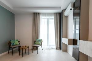 - un salon avec deux chaises et une fenêtre dans l'établissement Axxis Nova Resort & Spa, à Mamaia