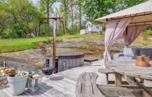 a patio with a grill and a wooden table at 4 Bedroom Cozy Home In Flo in Flo +22 photos