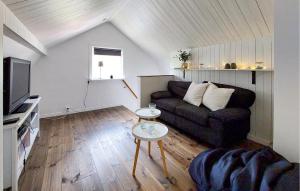 a living room with a couch and a tv at 2 Bedroom Cozy Home In Unnaryd in Sunnaryd