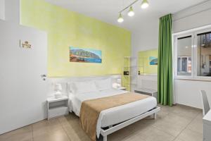 a bedroom with a white bed and a green curtain at Giufrania Rooms in Castellammare di Stabia