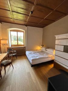 una camera da letto con un letto, una scrivania e una finestra di Klosterherberge Solothurn Self Check-in a Solothurn