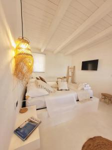 a white room with two beds and a tv at La Terrazza sul Faro in Porto Empedocle