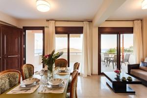 a dining room with a table and chairs and a couch at Villa Armonia - Beachfront Majestic Retreat in Petalidhion +41 photos