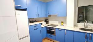 a blue kitchen with white counters and blue cabinets at Apto. En Mundaka in Mundaka