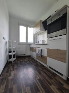 a large kitchen with wooden floors and a large window at Möbliert Wohnen in Weickelsdorf in Bahnhof Weickelsdorf