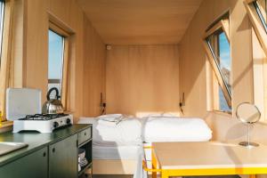 a small room with a bed and a table at Hihahut De Tuureluur in Oud-Ade