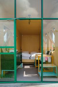 a room with a bed and a desk and a window at Hihahut De Tuureluur in Oud-Ade