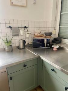 a kitchen with a counter top with a microwave at Wohnen im Stielwerk in Munster +64 photos
