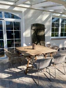 a wooden table and chairs on a patio at Wohnen im Stielwerk in Munster im Heidekreis