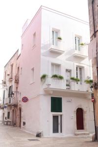 a white building with windows and balconies on a street at La Vitagira in Monopoli