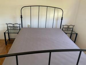 a metal bed with two chairs in a room at Vila Fjaka in Dugi Rat