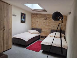 a bedroom with two beds and a lamp in it at Charmantes Studio Ferienhaus mit Garten & Netflix Nähe Spreewald in Heinersbrück