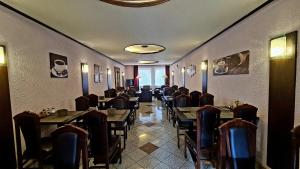 ein Speisesaal mit Tischen und Stühlen in einem Restaurant in der Unterkunft Hotel Zentrum in Hannover