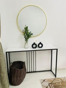 a mirror on a table with a plant and a basket at InAw Homestay Kok Lanas in Kampong Pangkal Petai