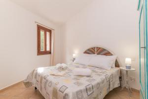 a white bedroom with a bed with two towels on it at La Dimora Di Montelittu With AC - Happy Rentals in Loiri